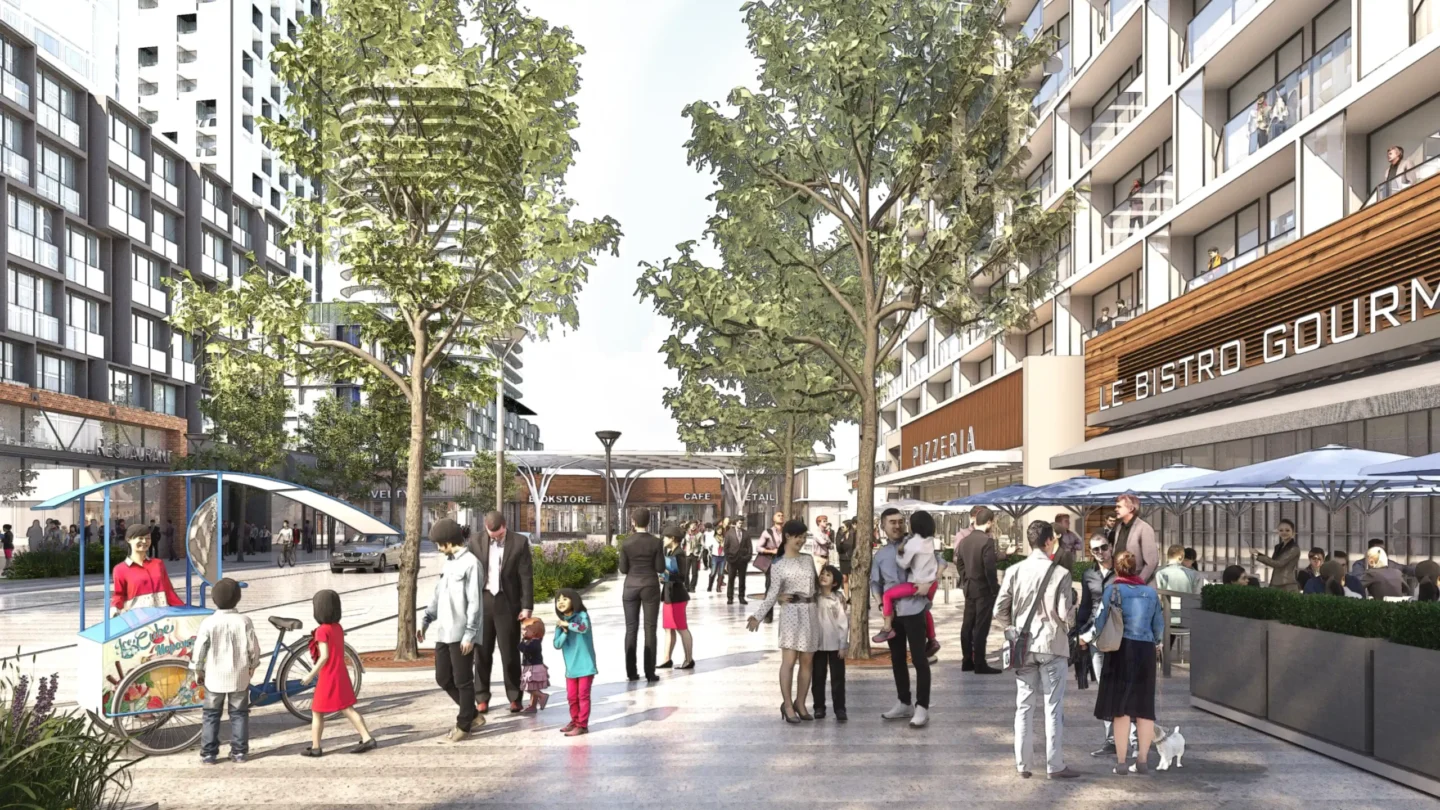 A vibrant urban streetscape featuring a wide pedestrian walkway lined with trees and modern mid-rise buildings. The street is filled with people of various ages and backgrounds engaging in everyday activities — walking, socializing, and shopping. On the left, a vendor on a tricycle cart sells ice cream to children. On the right, outdoor diners sit under umbrellas at a restaurant called "Le Bistro Gourmet" next to a "Pizzeria." Storefronts labeled “Bookstore,” “Cafe,” and “Retail” are visible in the distance. Above the shops, apartment balconies have residents looking out. The space is inclusive, family-friendly, and designed to support accessibility and community engagement.