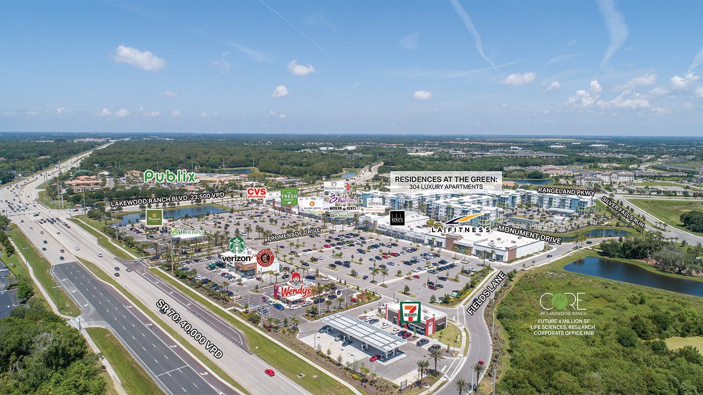 Aerial view of The Green at Lakewood Ranch shopping center with labels over major tenants like Publix, CVS, Starbucks, LA Fitness, Chipotle, and Wendy’s. The image also highlights apartment residences, roads, and future development areas surrounding the plaza.